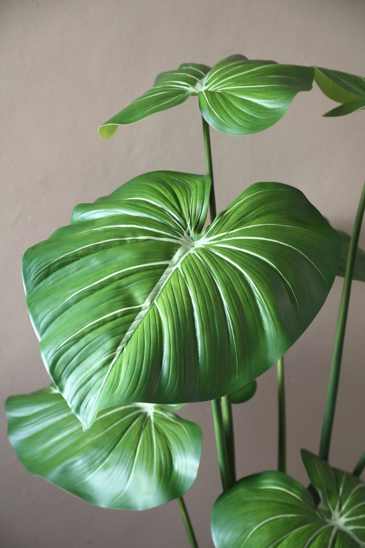 Leaves faux green plant in a black pot