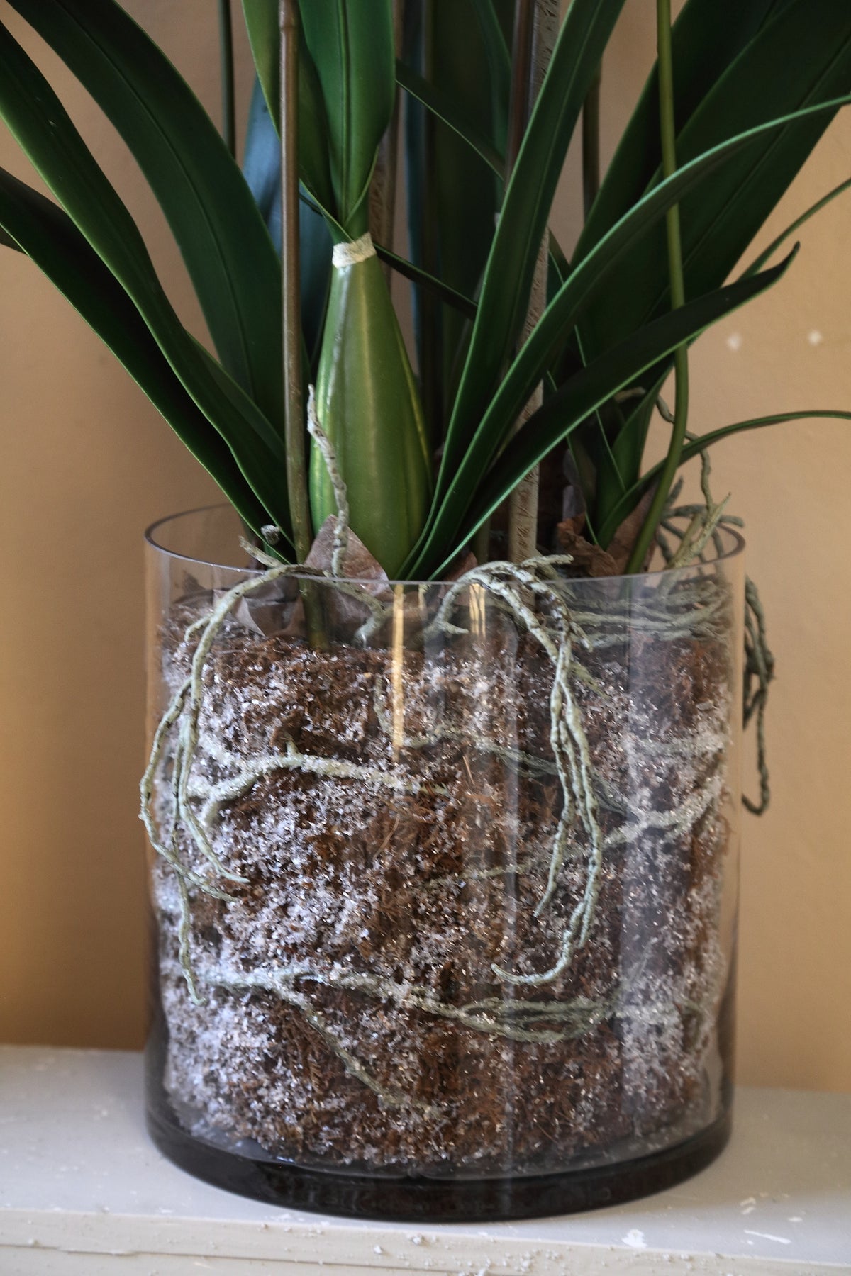 Orchid faux orchid in a glass vase, green